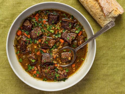 Bowl of beef barley soup with vegetables